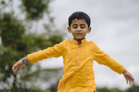 Kid at field with open armsの写真素材