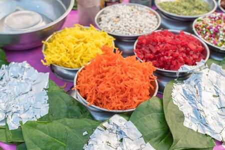 Different types of colorful garnish pan masala used to decorate betel leaf banarasi paan with selective focusの写真素材