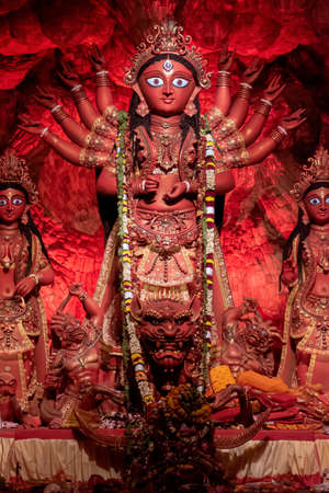 Goddess Durga idol at decorated Durga Puja pandal, shot at colored light, at Kolkata, West Bengal, India. Durga Puja is biggest religious festival of Hinduism and is now celebrated worldwide.のeditorial素材