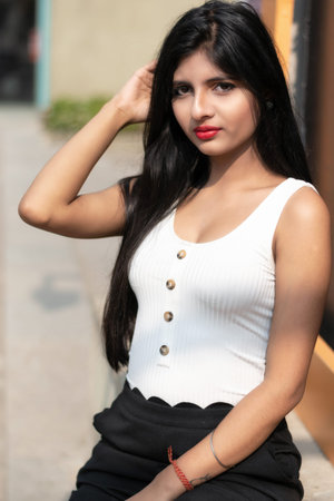 Portrait of very beautiful straight haired young attractive Indian woman wearing white and black...