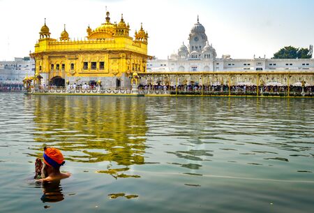 A sikh is praying in the holi water of Golden Temple Amritsar Indiaの写真素材