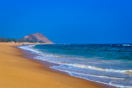Wild Empty Tropical beach, vibrant yellow sand, bright blue sky, crystal clear waters with water crashing on the shore at daytime on a sunny day in in as landscape style may be used as a background, wallpaper, screen saver Travel vacation concept. The image is exciting, bright, sensational, tranquil, calm, stunningの写真素材