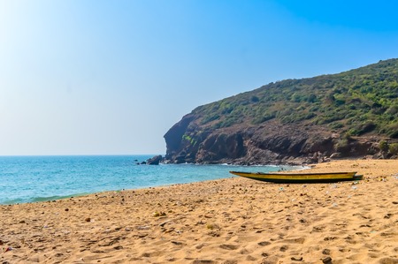 View of Fishing boats on beautiful sea shore at sunrise or sunset. Wild Empty Tropical beach, blue sky, yellow sand, sunlight reflections taken in landscape style may be used as a background, wallpaper, screen saver banner Travel vacation concept. The image is exciting, bright, sensational, tranquil, calm, stunning.の写真素材
