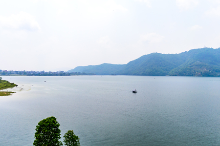 Photograph of autumn colourful lake mountain with clear sky. Wide angle landscape of Pokhara Lake at Kathmandu Nepal. Vintage film look. Vacation Freedom, Simplicity Concept.の写真素材