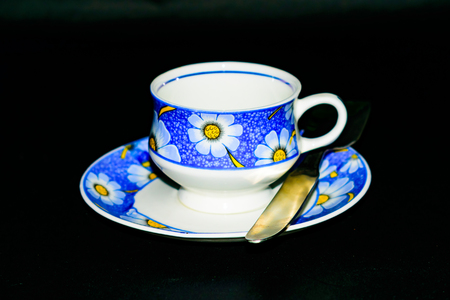 Single coffee cup on the plate with spoon in dark backgroundの写真素材