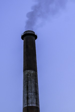 Exterior of maintenance and ventilation on top of a smoke tunnel, chimney for ventilation. Isolated old aged weathered tall industrial factory chimney grungy smokestack grunge vintage closeup blue skyの写真素材