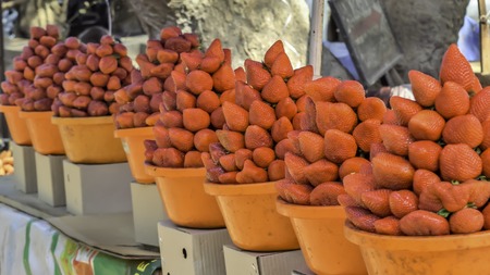 Pile of bright red strawberry cherries stacked on a stall display at an outdoor fruit and vegetable retail market in street of Mumbai Indiaの写真素材