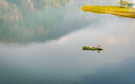 Lonely man in the sea with kayak after sunset. Sport and recreation during summer vacation concept.の写真素材