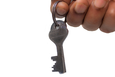 Close up of bunch of antique two iron metal keys attached on a ring, a real estate selling person holding it on isolated white background. Selective focus with copy space. Safe secure business conceptの写真素材