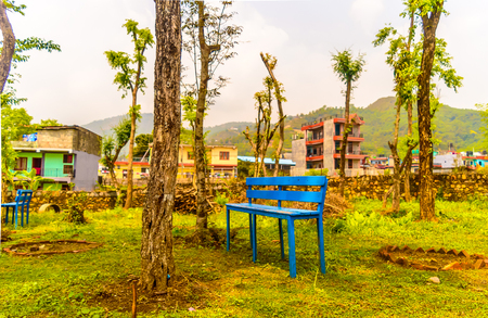 Bench in a front of park. Blue wooden chair in a formal garden. Idyllic mountain village and landscape, Kathmandu Nepal. Holiday concept. Architecture exterior design concept.の写真素材