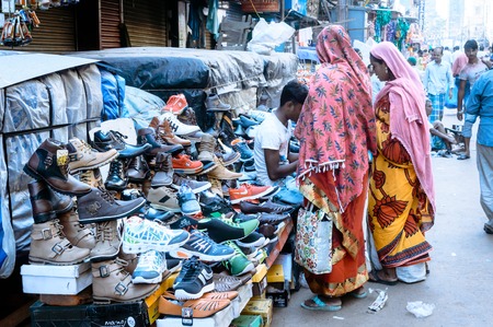 Burrabazar, Kolkata, India MAY, 2017: A seller is selling shoes in the street market. Burrabazar (Bara Bazaar) is a marketplace for stylish leather products, the largest wholesale markets in India.のeditorial素材