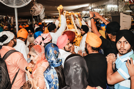 Amritsar, India - MAY 16 2016: Sikh people trying to touch the holi idol when it was taken out of the temple premises for decoration. Golden Temple is the holiest Gurdwara of Sikhism.のeditorial素材