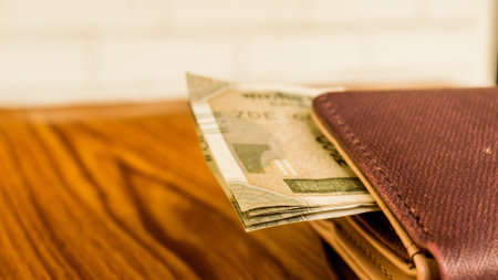 Indian five hundred (500) rupee cash note in brown color wallet leather purse on a wooden table....