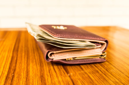 Indian five hundred (500) rupee cash note in brown color wallet leather purse on a wooden table....
