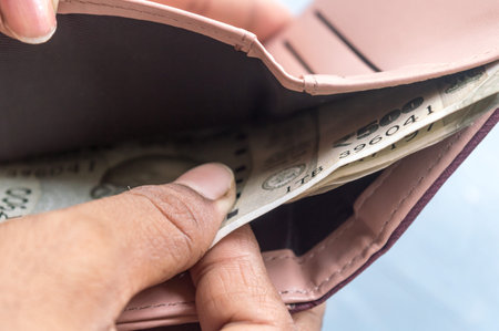 Businesswoman putting or taking out or paying Indian rupee banknotes from leather wallet. Isolated...