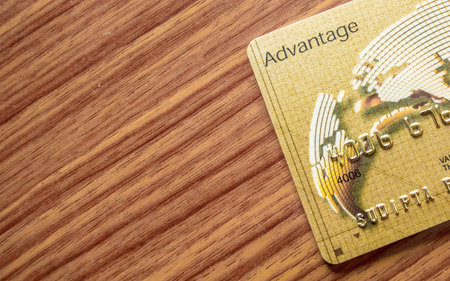 A part of credit card lying on wood table background. Online shopping concept.