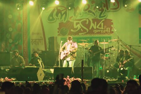 Kolkata India 1 May 2019 - Guitarist performing rock concert venue with lit bright colorful stage lights and fans or cheering crowd in front of it. Summer music festive background concept.のeditorial素材