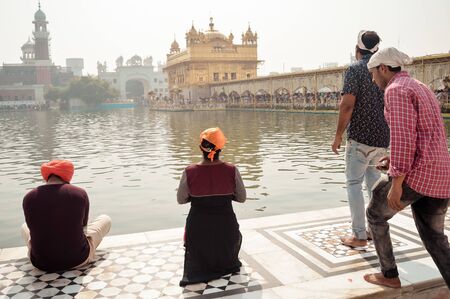 Golden temple (Harmandir Sahib Darbar Gurudwara), Amritsar, India May 2019 - Unidentifiable Punjabi Sikh pilgrim devotee "Nihang Warrior" meditating in front of holi lake of Golden Temple.のeditorial素材