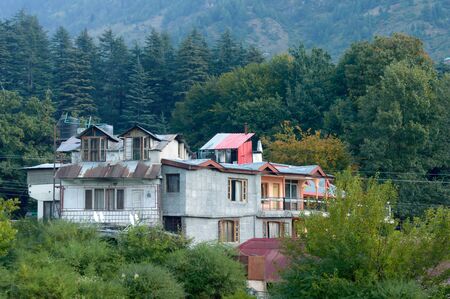Panoramic Old Hotel cottage retro style building surrounded with pine woodland trees in springtime himalayan mountain valley. Beauty in nature wallpaper decor background. Manali, India May 2019のeditorial素材