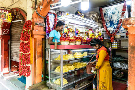 A market stall showing Hindu devotional Puja items or religious offerings, sweet food flowers at Dakshineswar Kali temple Street store Kolkata West Bengal India South Asia Pacific March 2020のeditorial素材