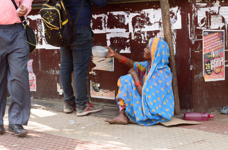 Old elderly Homeless woman begging in the city street corner of Kolkata, West Bengal, India South...