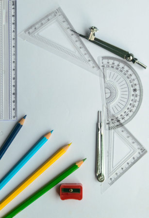 Geometric Measuring tools, Drawing items and mathematical instruments placed on white paper sheet....