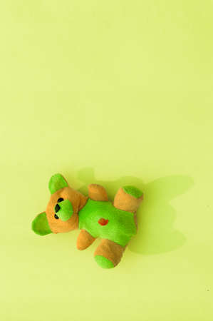 Rabbit teddy bear on yellow color background. Table top view. Vertical. Flat lay. Copy space for text.の写真素材