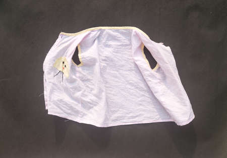 White shrunken baby clothes on floor after laundry washing. Due to laundry the cotton fibers shrink than normal size. Table top view. copy space for text.の写真素材