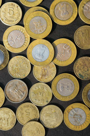 Mix of Gold Colored Indian Rupee Coin currency on rustic floor. Full Frame. Table Top View. Vertical. Business Finance and financial Investment Background. Close Upの写真素材
