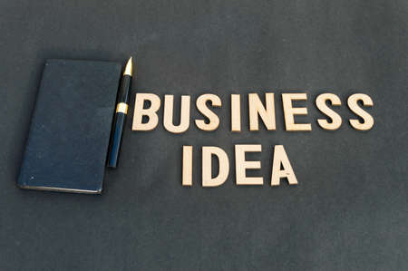 business idea background concept. Wooden cubes words Business ideas isolated on black background. Design for ideal poster, web, cover, ad, social media, promotion.の写真素材