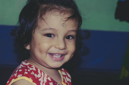 Portrait Of Adorable Cute Indian happy funny baby with dimples age one year six months smiling and Posing looking at camera. Happy Childhood And Child Care Concept.の写真素材