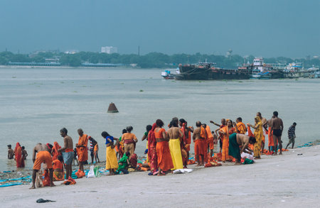 Pilgrim People are taking bath at the riverbank of the Ganges or river Hooghly . Babu Ghat, Kolkata, West Bengal, India. August 2, 2022のeditorial素材