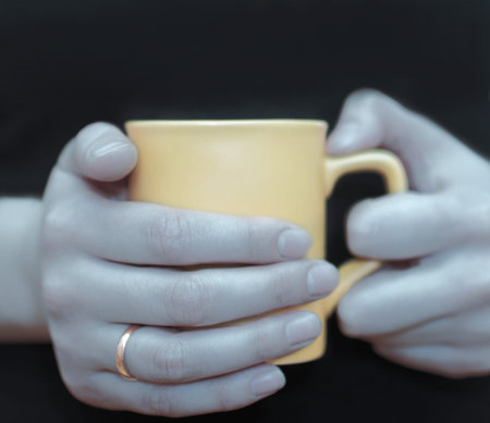 picture of women's hands with a bright cup; a wedding ring. A symbol of marriage; hearth; family and...
