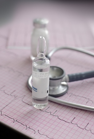 ampoule on the background of stethoscope, and ECGの写真素材