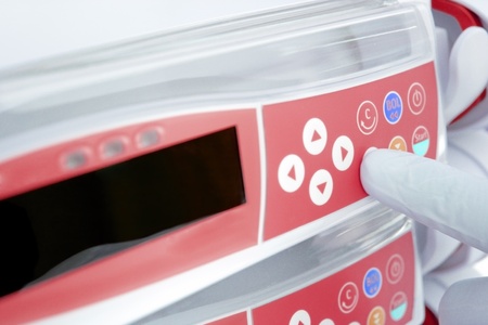 gloved finger, pressing the button of the modern device  photoの写真素材