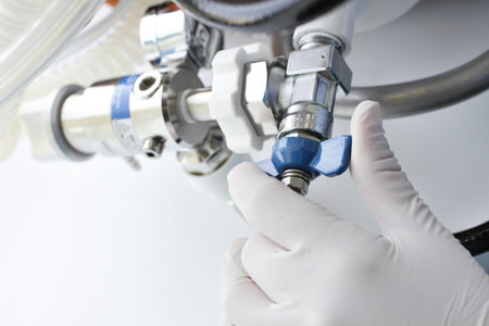 Work with medical gases  Hand of specialist untwists oxygen cylinder valve  