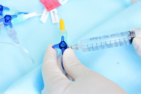 work with the venous catheter  One can see the hands of nurse, multiport central venous catheter, syringe with a solution の写真素材