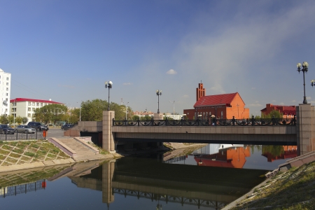 Astana  Urban landscape with a creek, the bridge, the Catholic church の写真素材