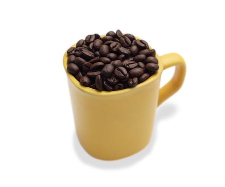 coffee beans in a yellow ceramic mug. Yang isolated white background.の写真素材