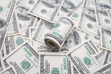 roll of dollars on 100 dollar bills backgroundの写真素材