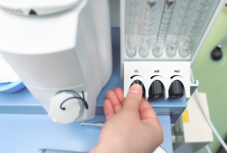 doctor adjusts the parameters of medical rotameter on the anesthetic setの写真素材
