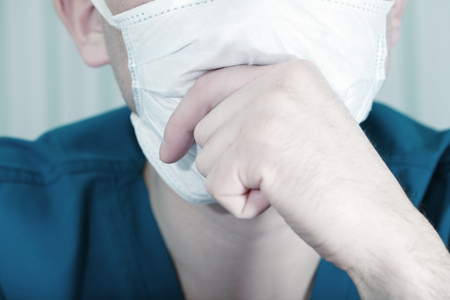 Man wearing a surgical mask thinkingの写真素材
