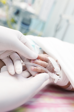 Doctor holding the hand of critically ill child の写真素材