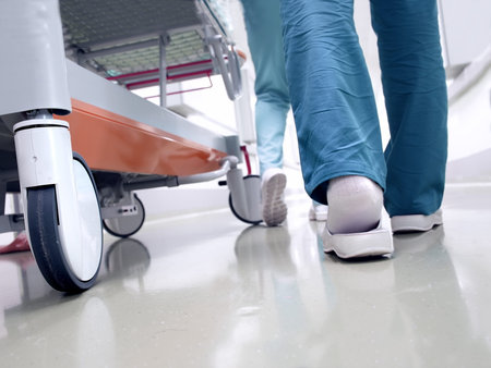 Medical staff moving patient through hospital corridor
