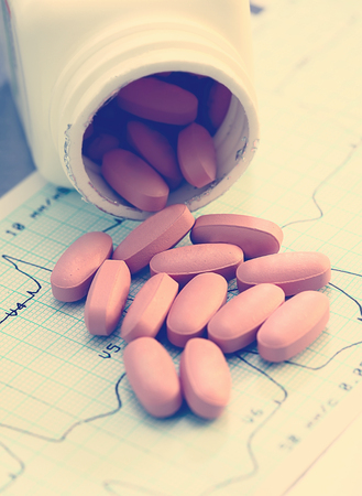 Medicinal pills on human cardiogramの写真素材