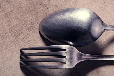 Old frayed cutlery on textile backgroundの写真素材