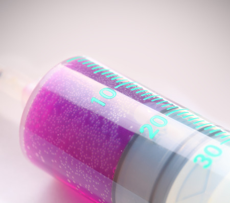 Medical syringe with pink contents isolated on white backgroundの写真素材