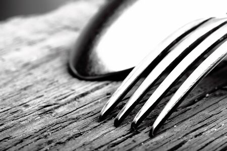 Spoon and fork on wooden background macroの写真素材