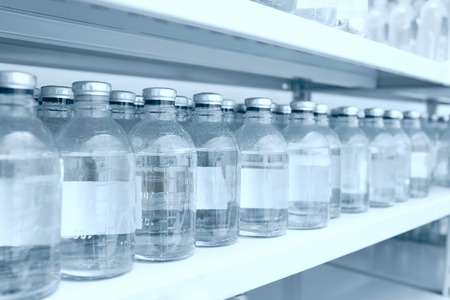 Medicine bottles in row on storage shelf in hospitalの写真素材