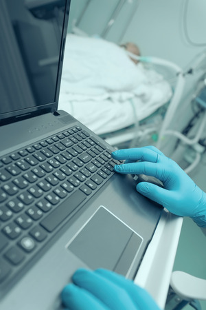 Doctor working on laptop in the intensive care wardの写真素材